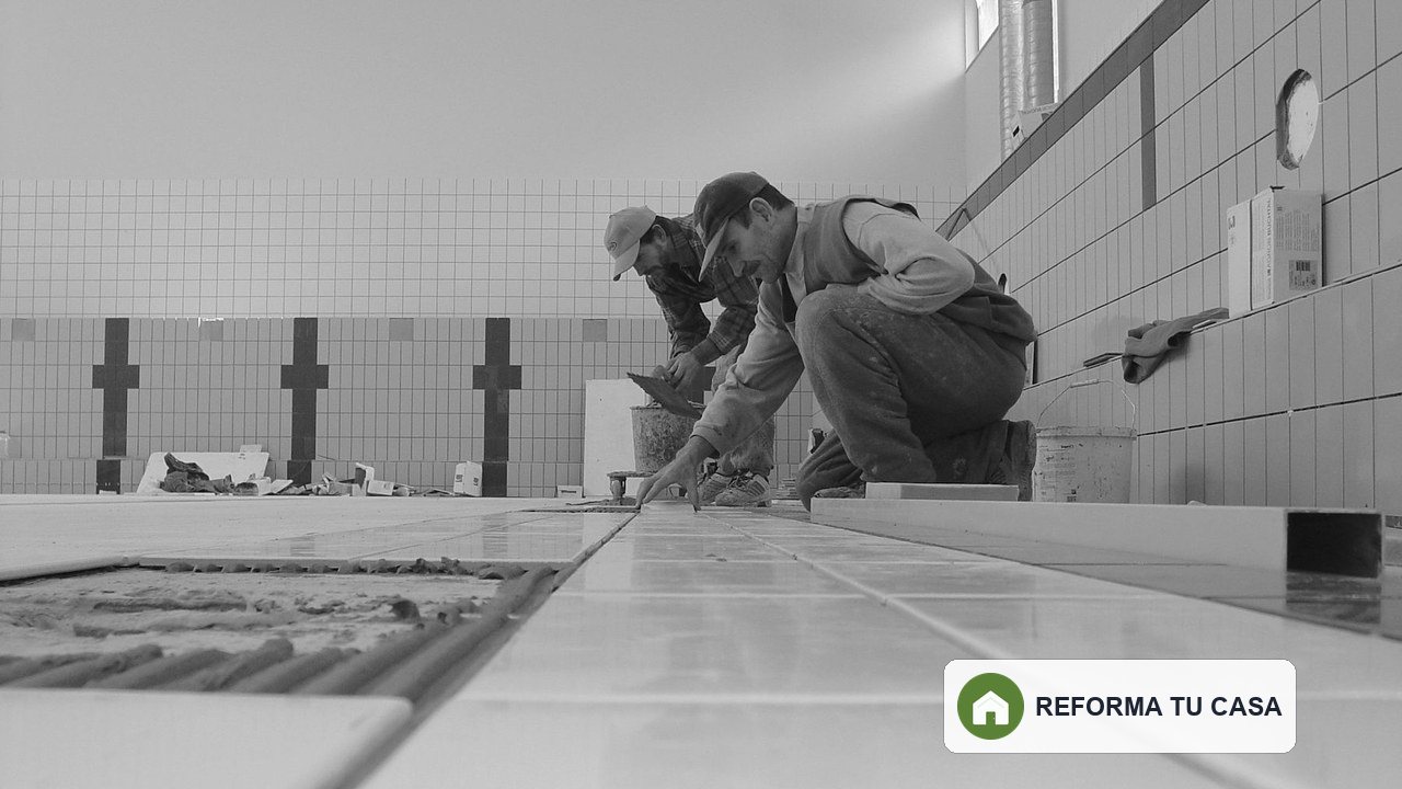 Profesionales replanteando y colocando revestimiento durante la reforma de un baño