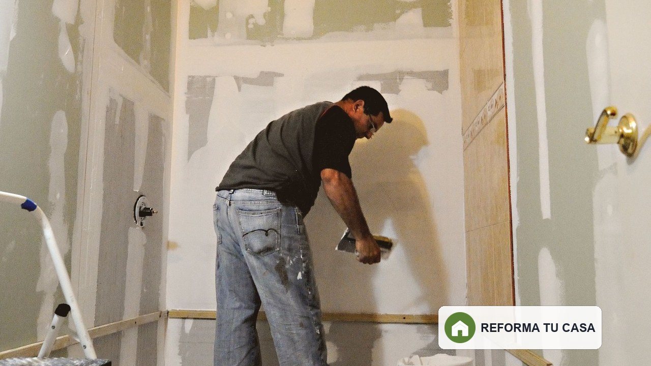 Profesional trabajando en las paredes de un baño durante la reforma