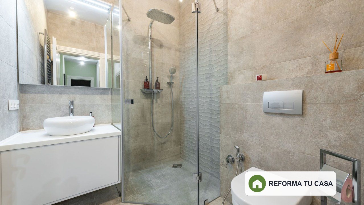 Baño reformado con ducha, espejo iluminado y luz de techo