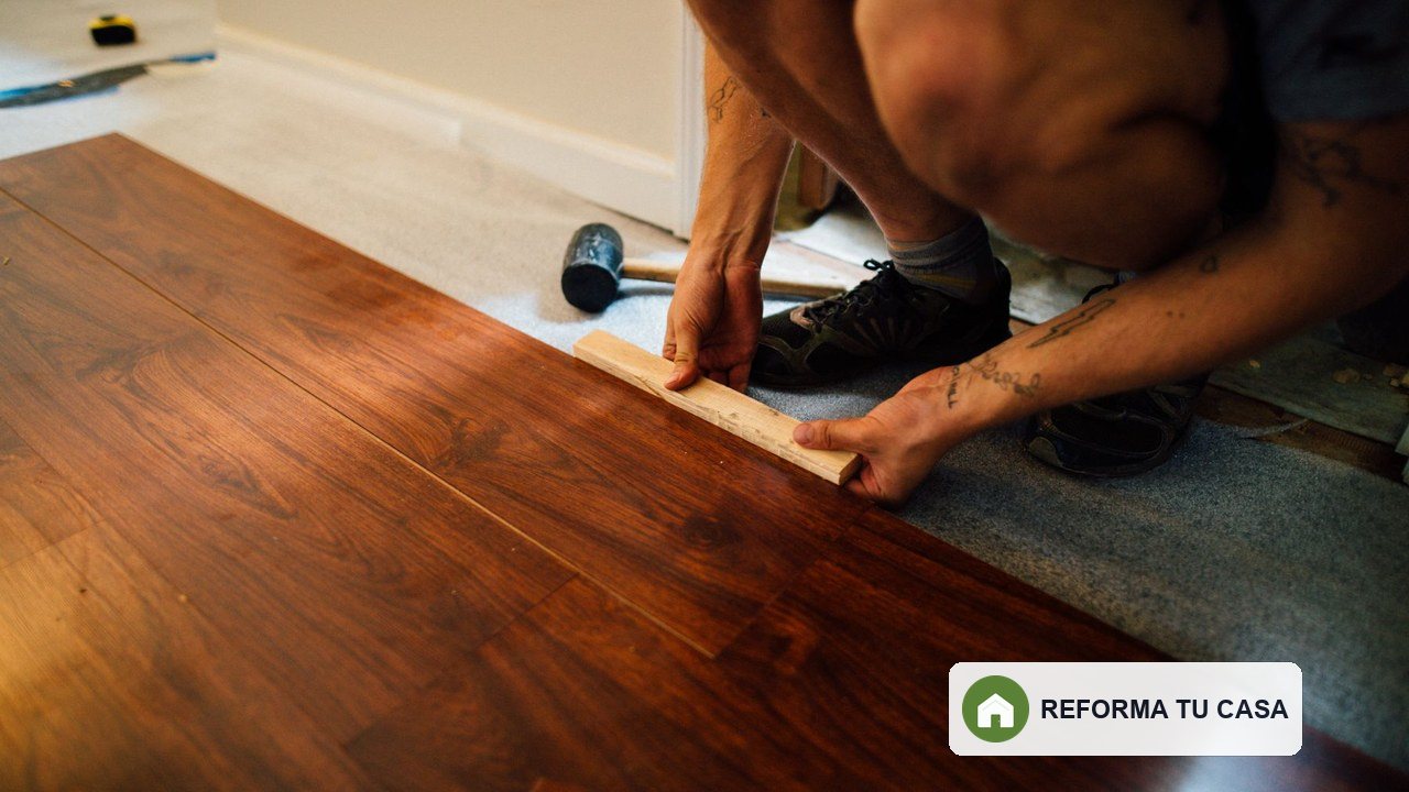 Instalador colocando lamas de suelo de madera sobre una base preparada
