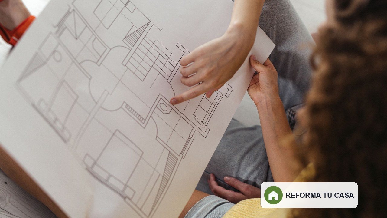 Dos personas revisando el plano de una vivienda antes de una reforma integral